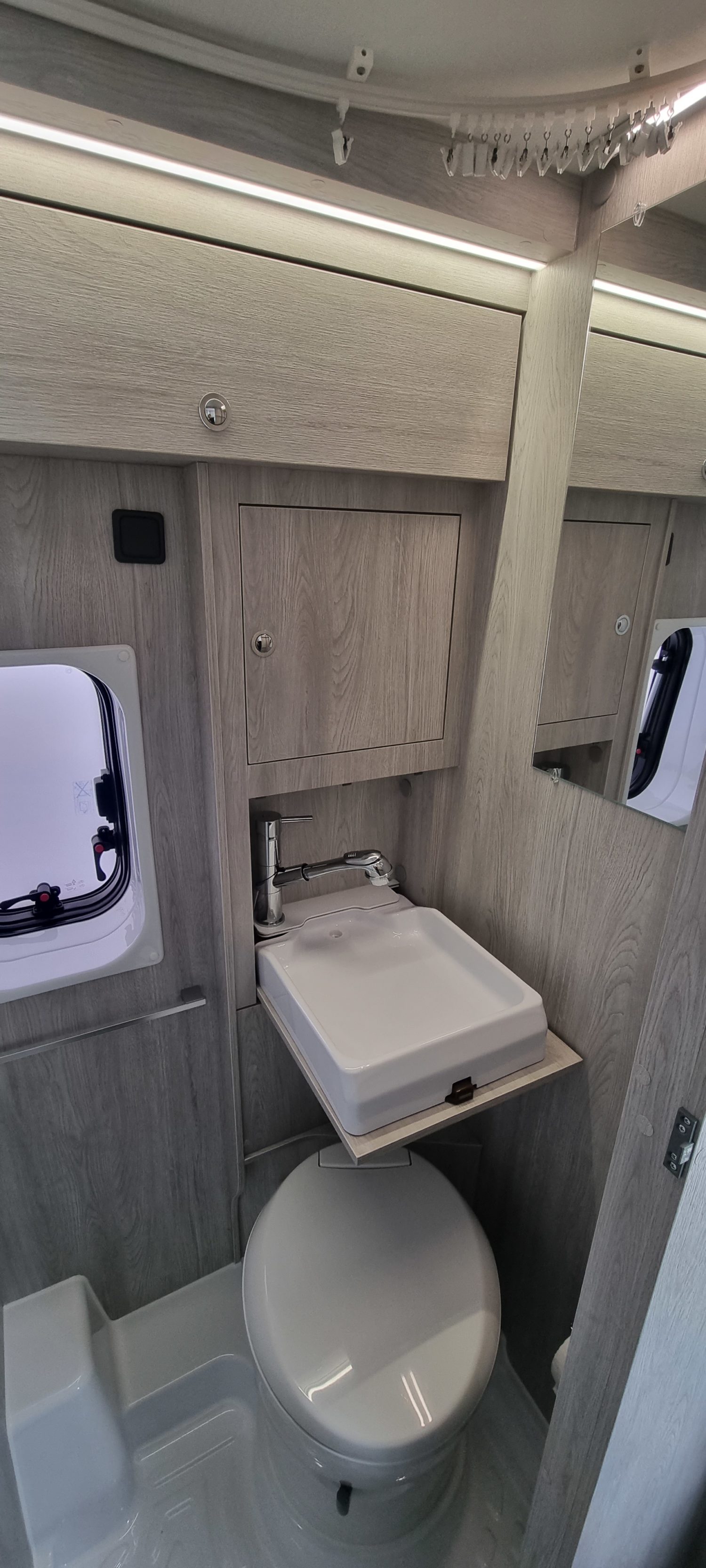 Camper Van Venedig, Blick in das Badezimmer mit herausgeklapptem Waschbecken mit Toilette und Dusche