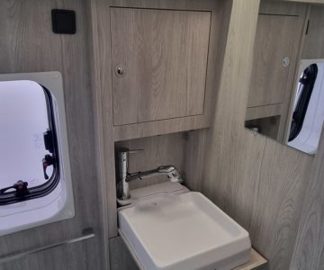 Camper Van Venedig, Blick in das Badezimmer mit herausgeklapptem Waschbecken mit Toilette und Dusche