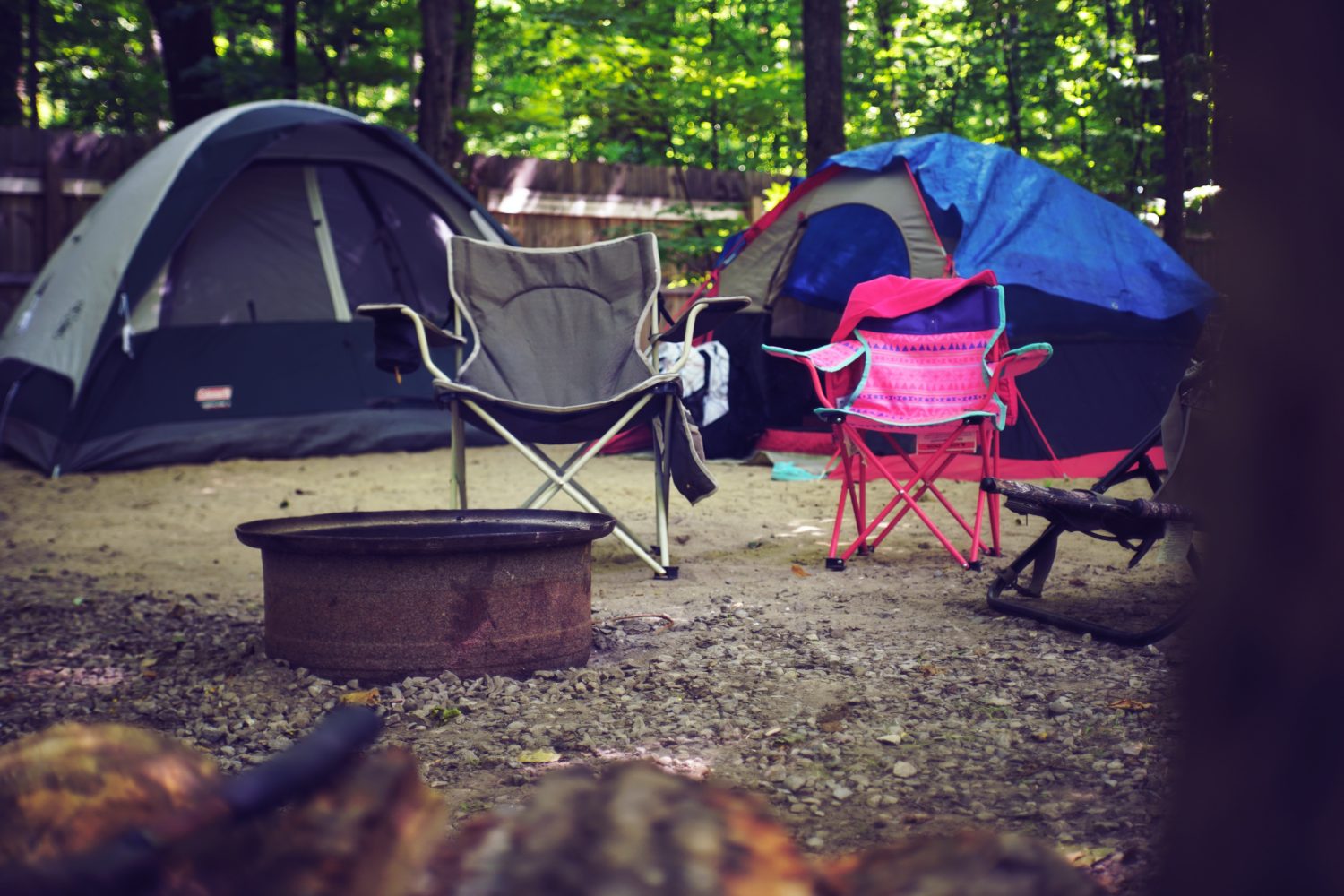 Zwei Zelte auf einem Campingplatz mit Campingstühlen im Vordergrund